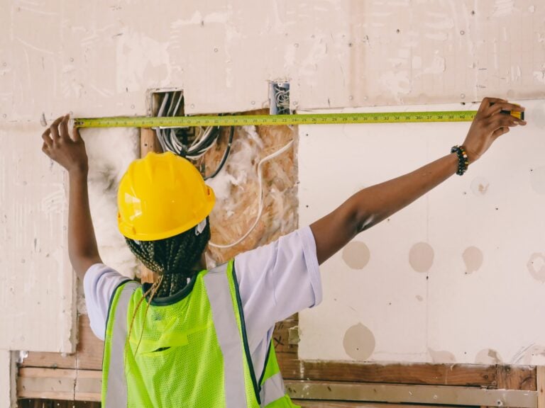 A woman measuring a wall
