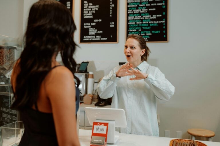 Cashier behind a Counter in front of a Customer